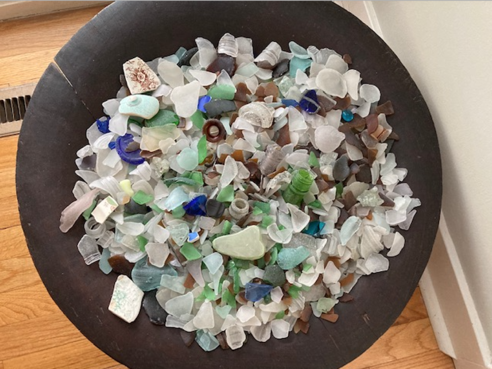 A bowl of sea glass of various different shades of blue, green, white