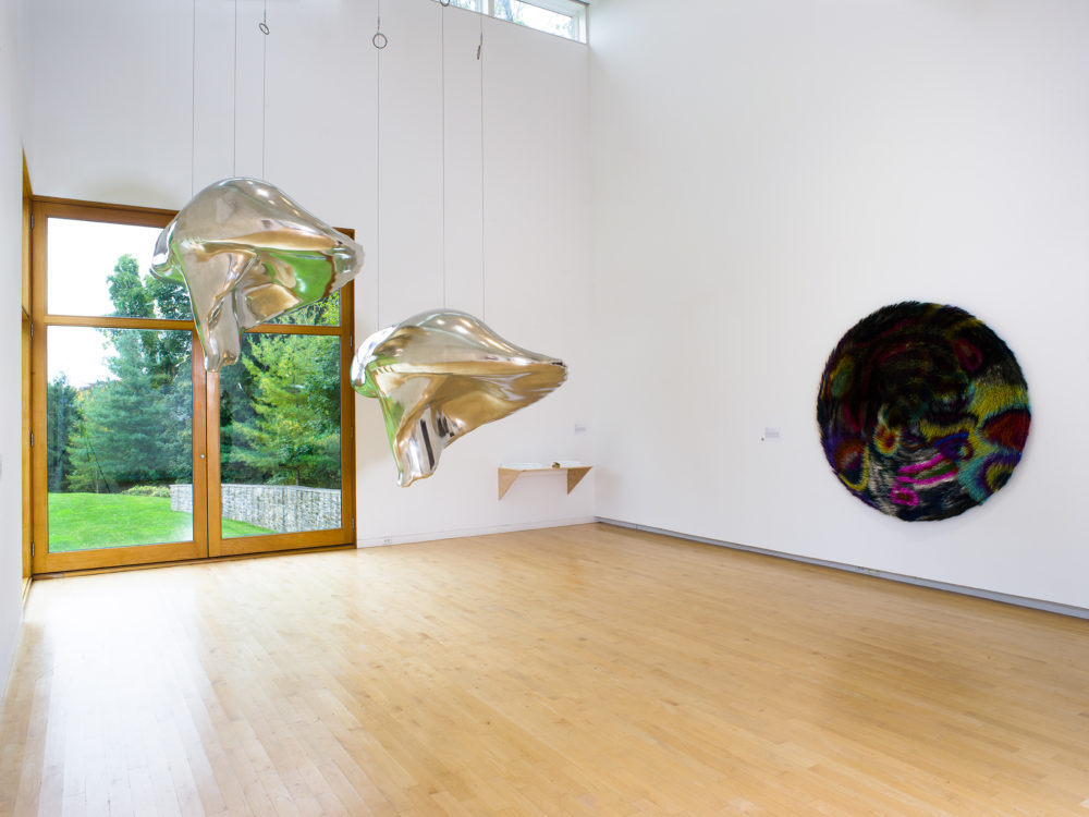 Two silver sculptures hang from the ceiling
