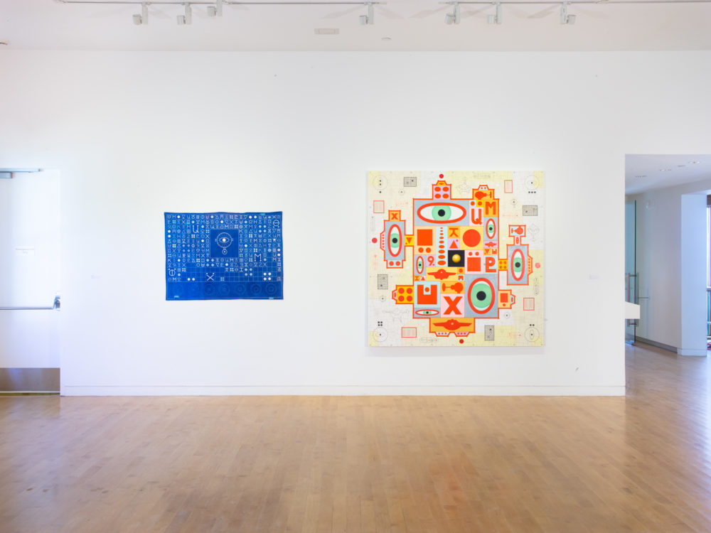 A blue painting on the left and a multi-colored painting with eye-like symbols on the right.