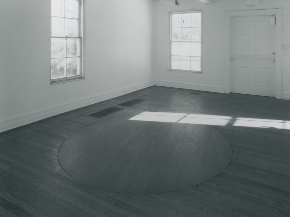 This is a photograph from Ann Hamilton's exhibition whitecloth which features a rotating floor board in the center of the gallery