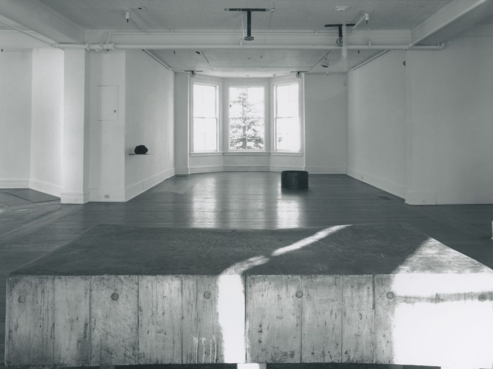 This is a photograph from Ann Hamilton's exhibition whitecloth, which features a large wooden table and many moving mechanisms