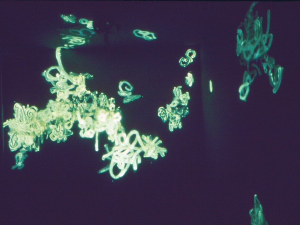 This is a photograph of a light installation which appears to glow green in the darkness