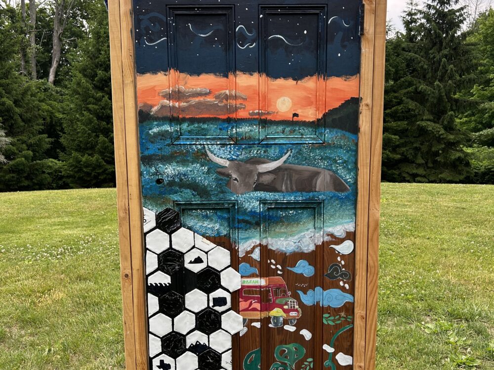 A painted door in a wooden frame installed on the grass