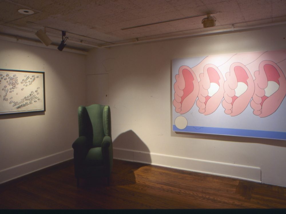This is a photo from the Pop Surrealism exhibition which shows a green chair and a vibrant pink piece of artwork